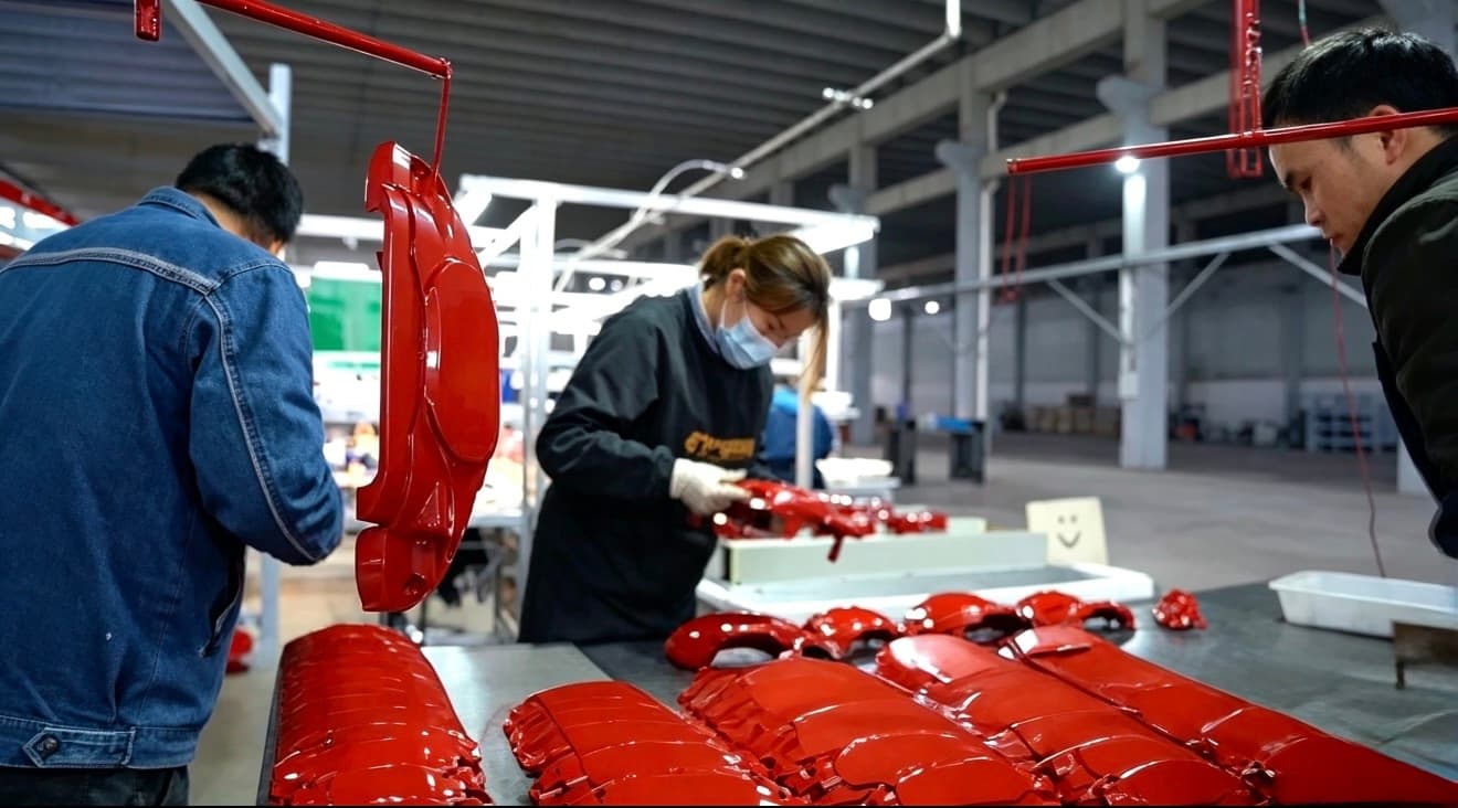Finished decorative brake caliper covers handled at an HSX project worktable