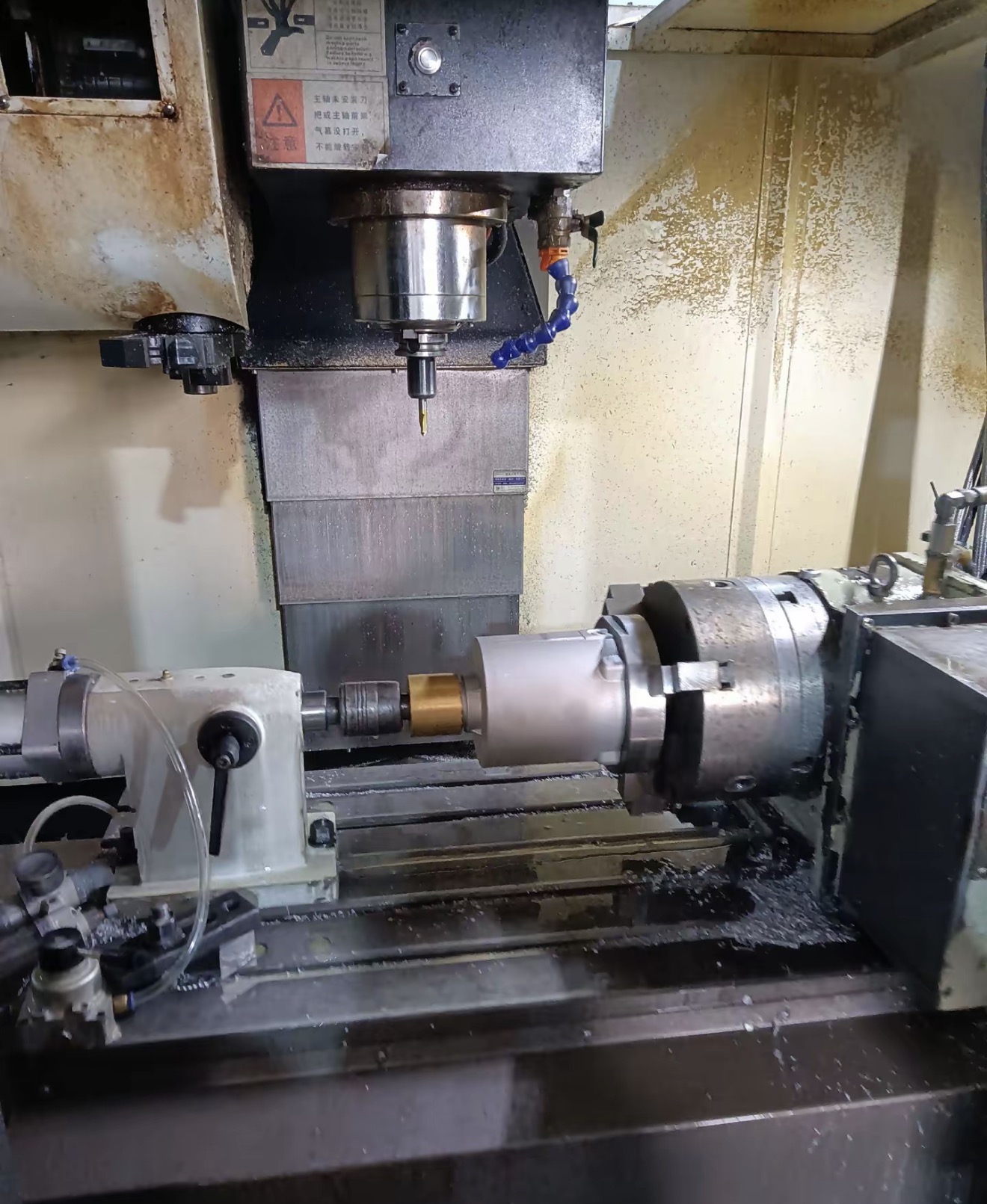 Machine tool setup holding a cylindrical aluminum housing for bore face and related feature machining
