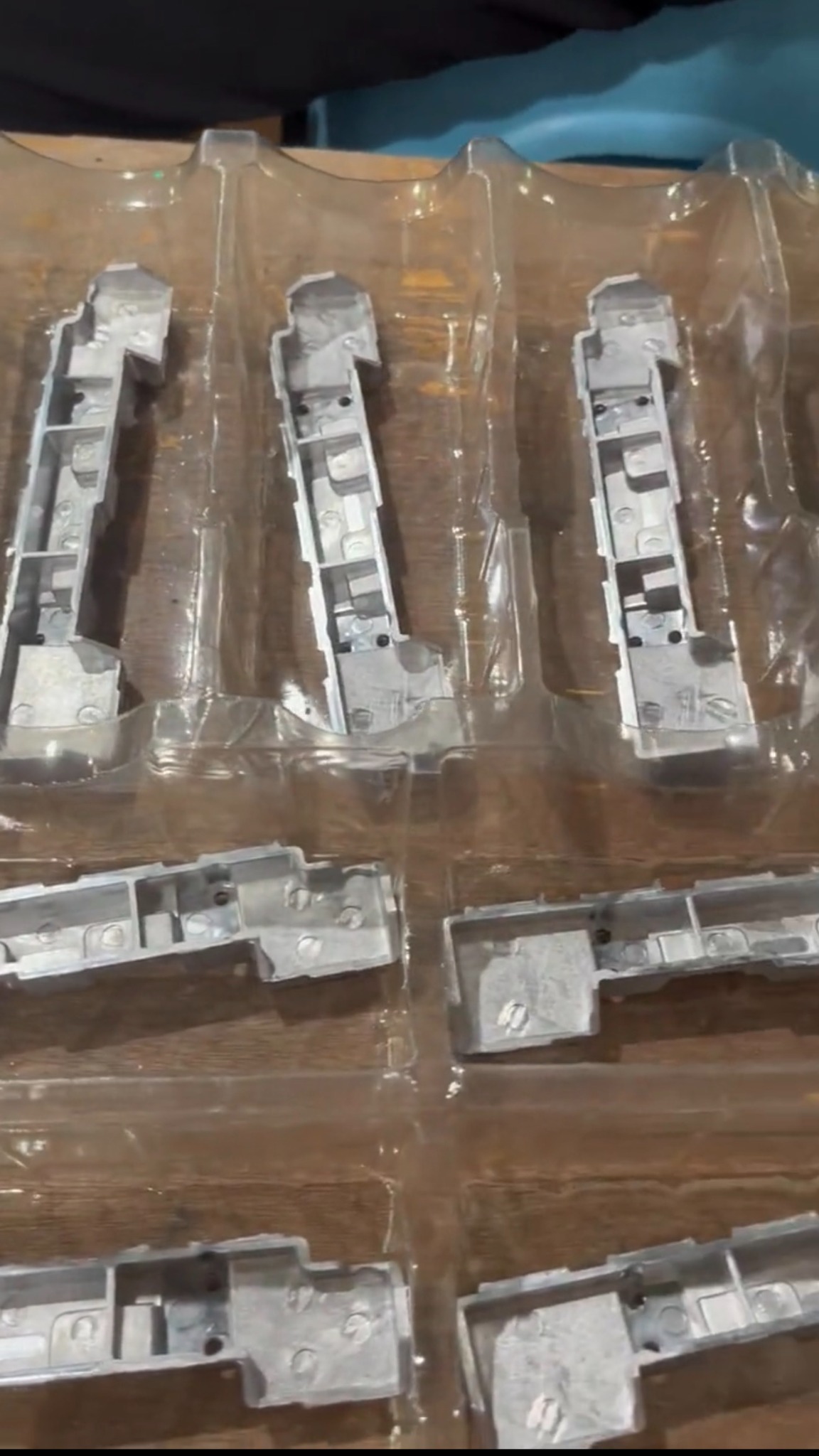 Elongated metal components placed in separate cavities of a clear formed tray.