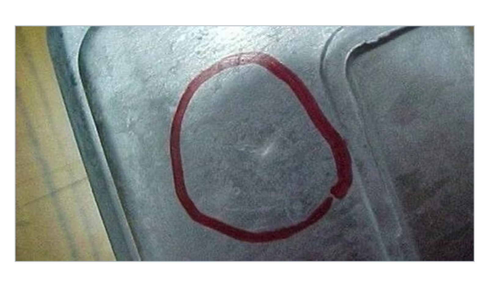 Close-up example of an aluminum die casting with a smooth local sink mark or surface depression highlighted by a red circle.
