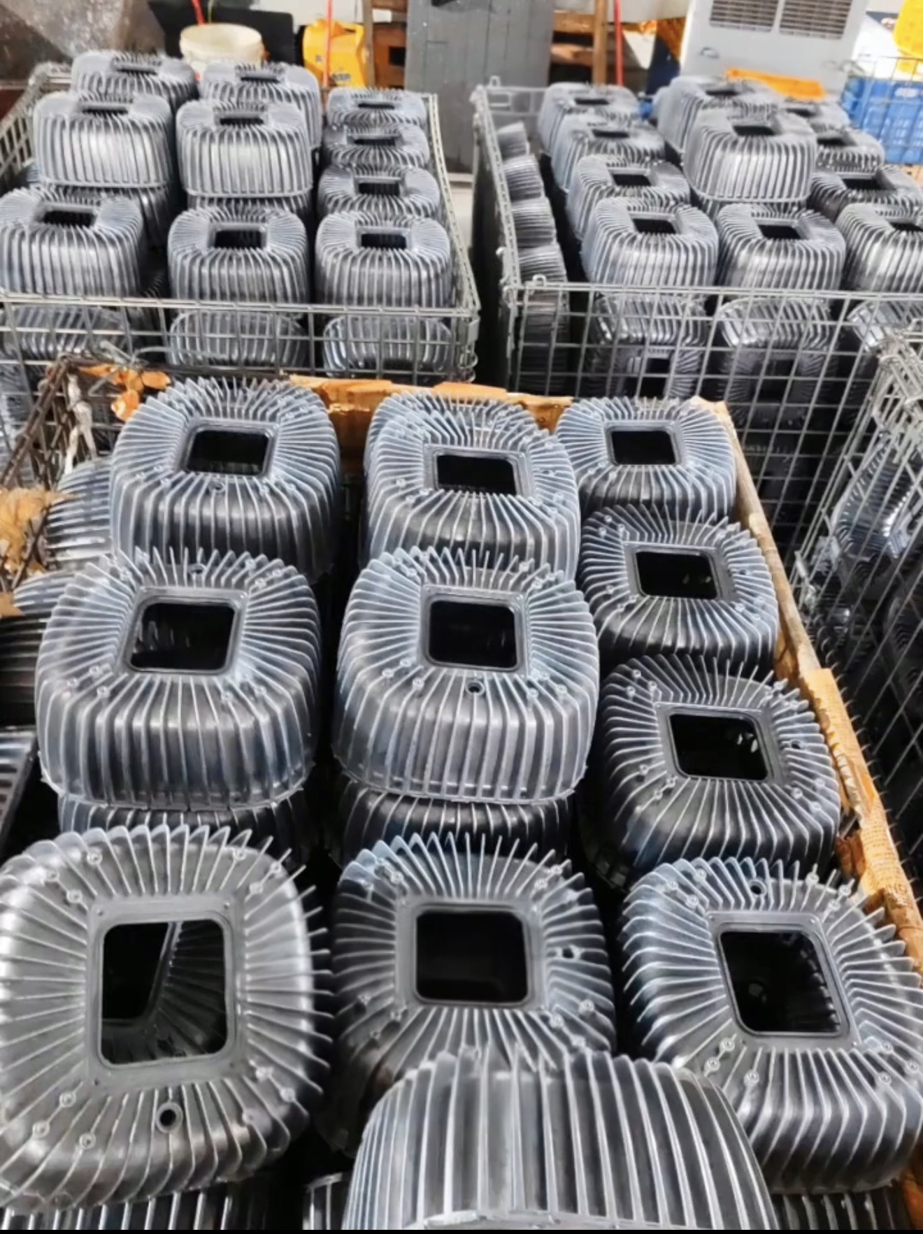 Finned aluminum die cast lighting housings arranged in containers
