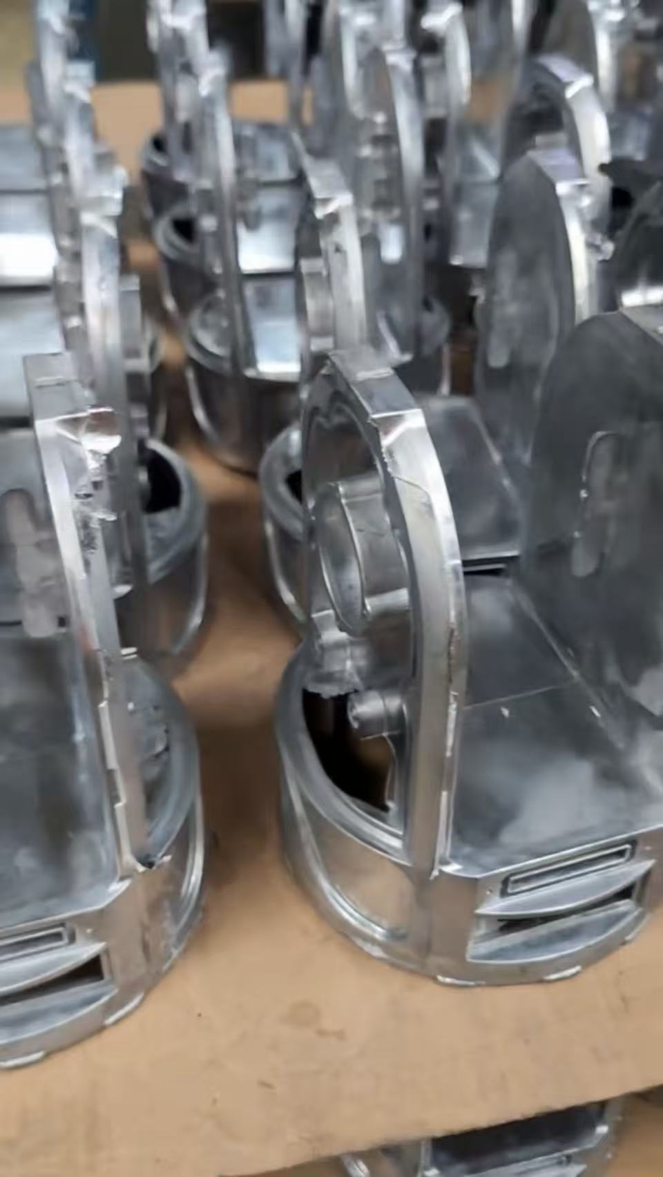 Batch of raw custom aluminum die-cast structural components.