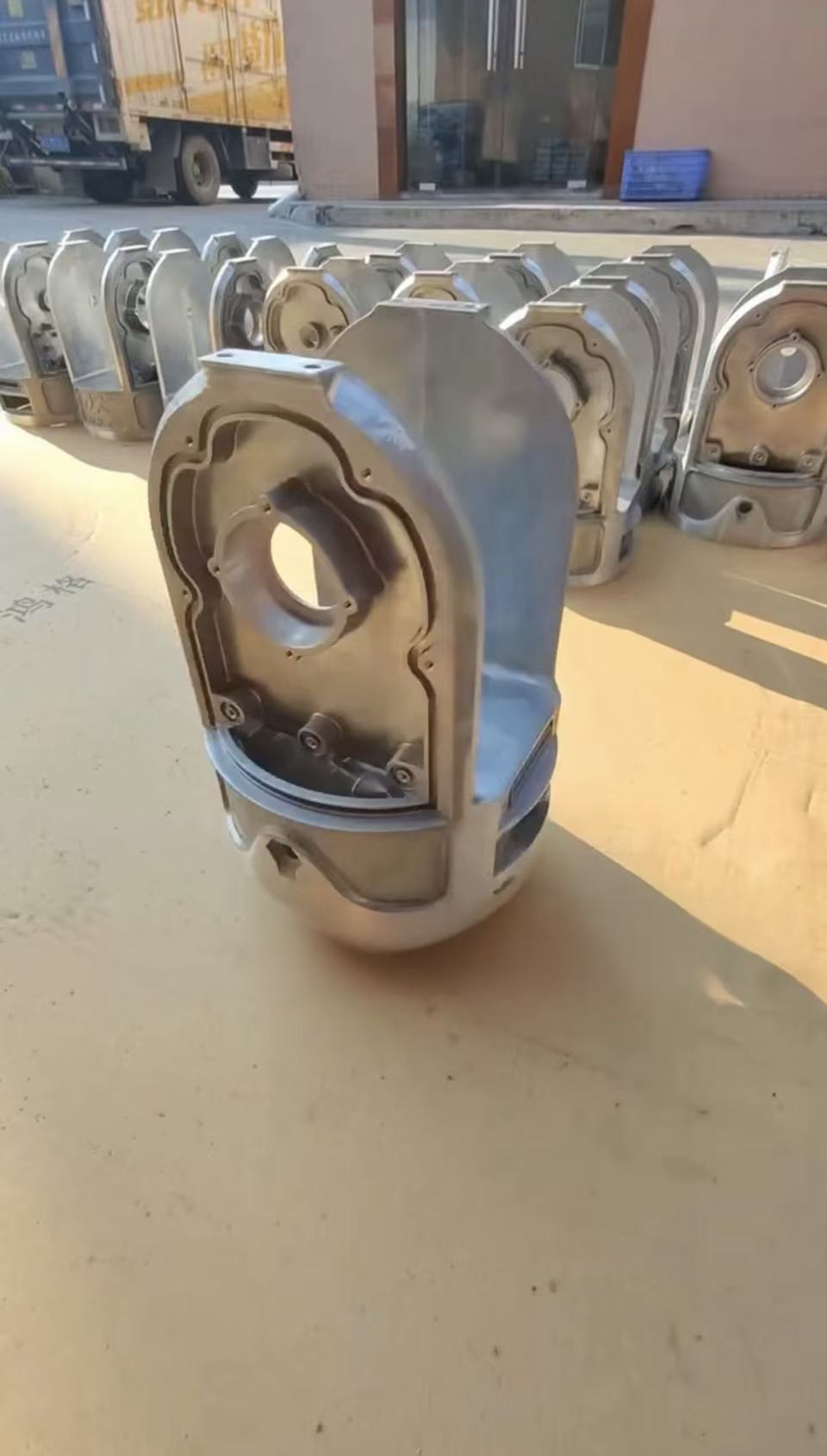 Batch of partially processed custom aluminum die-cast structural parts.